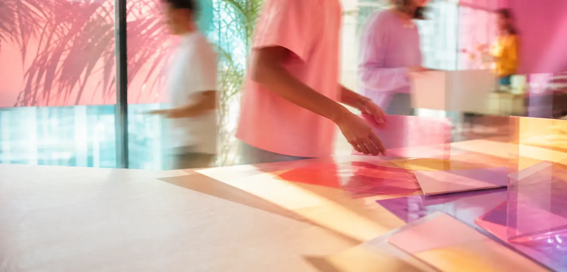 A team laying out translucent colour samples on a studio table